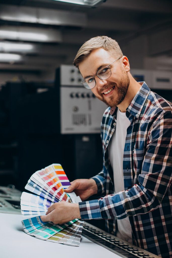 homem trabalhando em uma grafica com papel e tintas